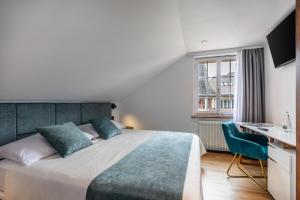 a bedroom with a bed and a desk and a window at Hotel Rheingerbe in Stein am Rhein +68 photos