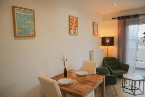 a dining room with a wooden table and chairs at L'échappée Alsacienne - Studio in Saint-Louis in Saint-Louis