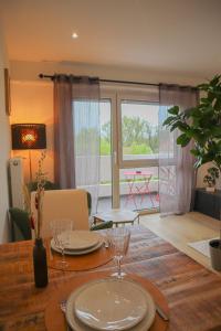 a dining room table with plates and glasses on it at L'échappée Alsacienne - Studio in Saint-Louis in Saint-Louis