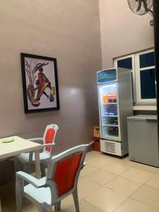 Una cocina con refrigerador y una mesa y sillas. en MoAde, en Ikeja