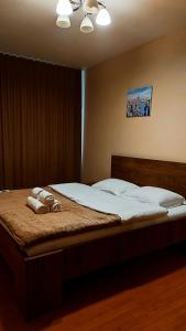 a bedroom with a bed with two towels on it at Запорізька 19 City Rooms in Bila Tserkva