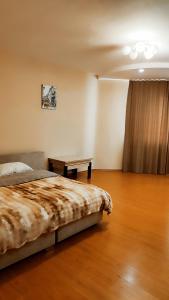 a bedroom with a bed and a table on a wooden floor at Запорізька 19 City Rooms in Bila Tserkva