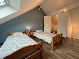 two beds in a room with a attic at Maison Arques-la-Bataille à 5min de Dieppe in Arques-la-Bataille