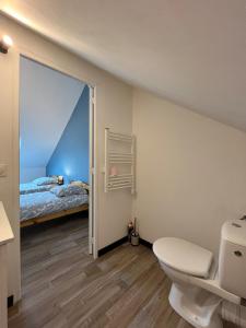 a bathroom with a toilet and a bed at Maison Arques-la-Bataille à 5min de Dieppe in Arques-la-Bataille