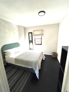 una camera da letto con un letto e una finestra di De Kalkery Apartment a Kalk Bay