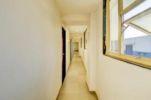 ein Korridor in einem Gebäude mit einem Fenster in der Unterkunft FabHotel World King in Pune