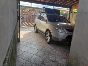 une petite voiture en argent garée dans un garage dans l'établissement Casa de praia, à Mongaguá