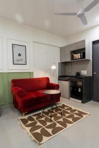 Una sala de estar con un sofá rojo y una mesa. en House of KP by Union, en Pune