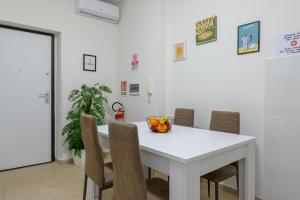 uma sala de jantar com uma mesa e cadeiras brancas em Villa Giavitto em Fiumicino