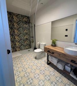 a bathroom with a toilet and a sink and a mirror at Alojamiento EL ESPOLON in Alba de Tormes