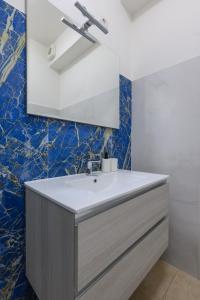 een badkamer met een wastafel en een spiegel bij Villa Giavitto in Fiumicino