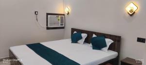 ein Schlafzimmer mit einem Bett mit blauen und weißen Kissen in der Unterkunft HOTEL RS Palace in Ghātsīla + 20 Fotos