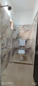 ein Badezimmer mit Toilette und Dusche in der Unterkunft HOTEL RS Palace in Ghātsīla