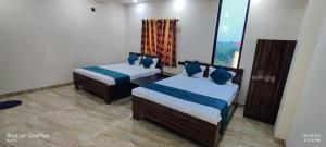 a room with two beds and a window at HOTEL RS Palace in Ghātsīla