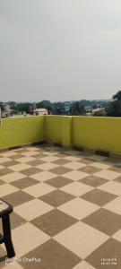 ein Balkon mit Schachbrettmusterboden und grünen Wänden in der Unterkunft HOTEL RS Palace in Ghātsīla