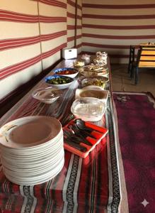 a buffet with plates and bowls of food on a table at Golden Day Bedouin Camp in Wadi Rum +25 photos