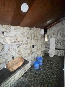 une salle de bain avec un mur en marbre avec des toilettes et un lavabo dans l'établissement PARI villa, à Lonavala 21 autres photos