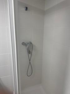 a shower with a shower head in a bathroom at Hostal Marcela Berge in Berge