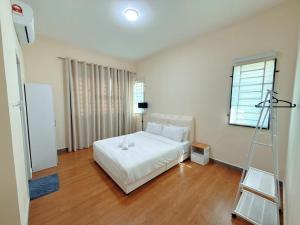 a bedroom with a white bed and a ladder at EQAMEL Homestay in Sandakan