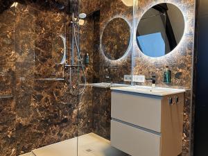 ein Badezimmer mit Dusche, Waschbecken und Spiegel in der Unterkunft De Parel - In de winkelstraat in Breda