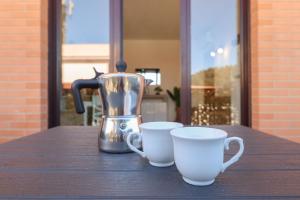 a coffee maker and two cups on a table at Masi House in La Massimina-Casal Lumbroso