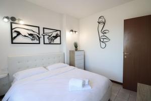 una camera da letto con un letto bianco con tre immagini sul muro di Masi House a La Massimina-Casal Lumbroso
