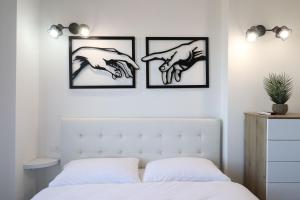 una camera da letto con tre quadri di mani sul muro di Masi House a La Massimina-Casal Lumbroso Altre 29 foto