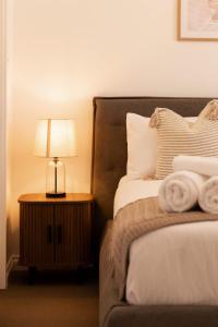 The Iluka Mirage - Sauna - Spa - Heated Pool - Fire pit - 5BR في بيرث: غرفة نوم بها سرير ومصباح على طاولة +37 صورة