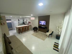 ein Wohnzimmer mit Couch und Küche in der Unterkunft Linda casa em Tarituba in Paraty