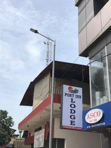 ein Geschäft mit einem Schild an der Seite eines Gebäudes in der Unterkunft Port Inn Lodge in Mangaluru