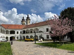 a building with a yellow car parked in front of it at Forst Apartman in Eger