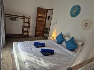 Buku Lodge Villa Spa Lombok في سيلونغ بيلاناك: غرفة نوم عليها سرير ومخدات زرقاء +44 صورة