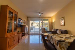 ein Hotelzimmer mit einem Bett und einem Wohnzimmer in der Unterkunft Global Properties, Piso practico, con terraza y piscina en la playa de Canet in Canet d'en Berenguer