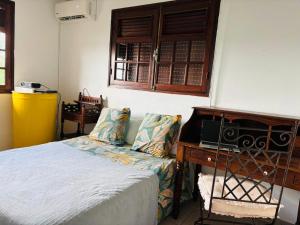 a bedroom with a bed and a desk with a radio at Chambre d'Hôtes Créole Bas du Fort in Le Gosier