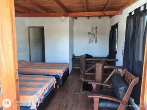 a room with two beds and a chair in it at Cabaña Anisacate in Villa Anizacate