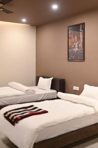 two beds in a room with a picture on the wall at Oak House in Dimāpur
