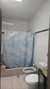 La salle de bains est pourvue de toilettes et d'un rideau de douche bleu. dans l'établissement Pausa mendocina centro, à San Rafael 16 autres photos