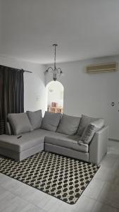 un canapé gris dans un salon avec un tapis dans l'établissement Pausa mendocina centro, à San Rafael