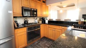 a kitchen with wooden cabinets and a black counter top at Family Tides in Cape May