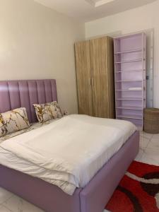 レッキにあるThe Homely Retreatのベッドルーム(紫色のヘッドボード付きの大型ベッド1台付)