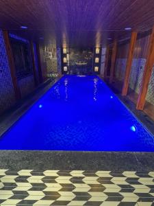 une grande piscine bleue dans une maison dans l'établissement PARI villa, à Lonavala