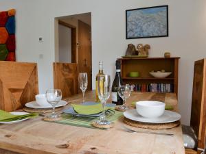 a wooden table with wine glasses and plates on it at Glan-Y-Gors in Beddgelert