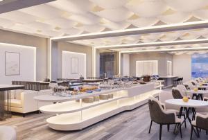 a restaurant with white tables and chairs and a ceiling at HYVE Siliguri in Siliguri