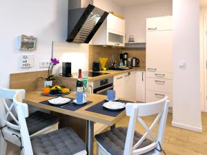 a kitchen with a wooden table with chairs and a counter at Baabe Villen-Ensemble FeWo 41 Muschelsucher in Baabe