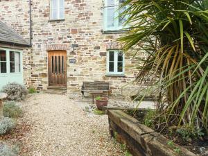 a brick house with a bench in front of it at Turneys Cottage - Uk42115 in Bodmin