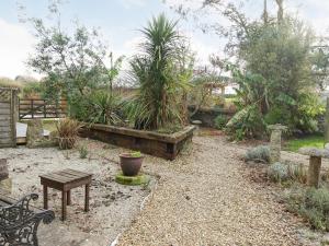 a garden with a bench and a table and plants at Turneys Cottage - Uk42115 in Bodmin