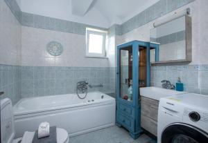 a bathroom with a tub and a toilet and a sink at Green Hill Villa in Daratso