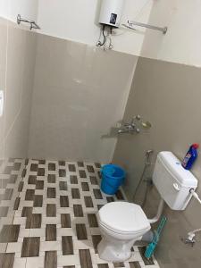 a bathroom with a toilet and a checkered floor at Prime Place Guesthouse in Dibrugarh