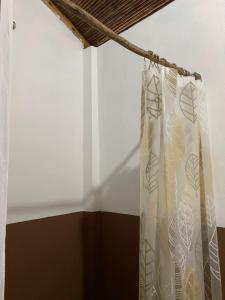 ein Vorhang in einem Zimmer mit einer weißen Wand in der Unterkunft Popoyo Surf House Guasacate in La Albina