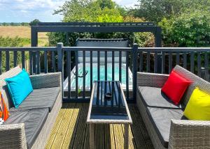 eine Terrasse mit zwei Stühlen und einem Tisch mit bunten Kissen in der Unterkunft Raywell Hall Country Lodges in Skidby